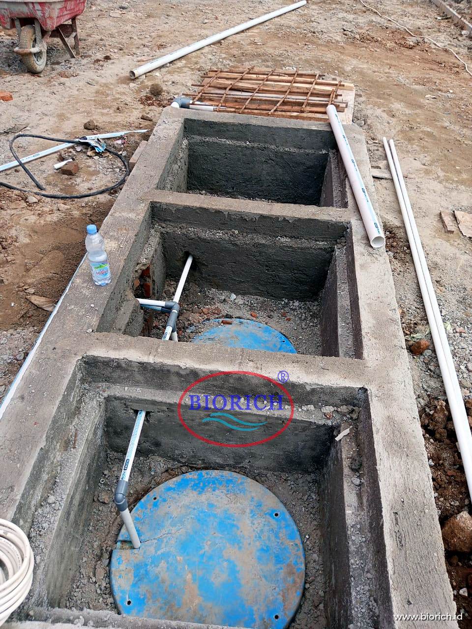 Bak kontrol beton dengan tutup manhole tangki IPAL di bawahnya, memudahkan pemeriksaan dan penyedotan